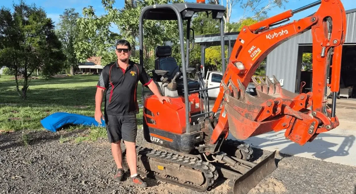 Luke beside his 1.7-tonne Kubota excavator on a Toowoomba job site