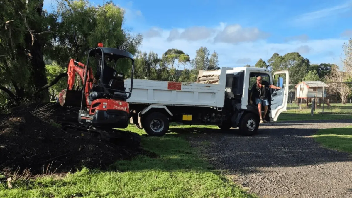 Luke's signed tipper truck and Kubota excavator parked on a Toowoomba job site in daylight